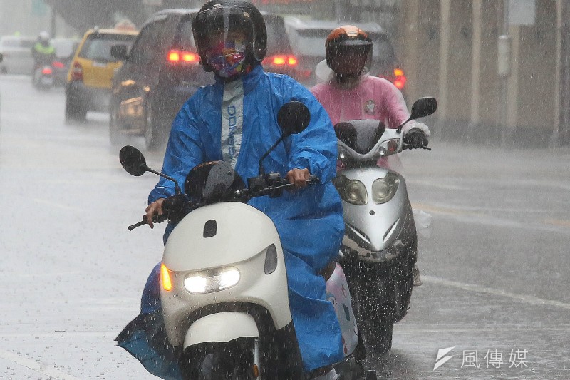 受颱風外圍環流影響，台北市區12日間歇性下雨，機車騎士身著雨具在雨中騎乘。（資料照／柯承惠攝）