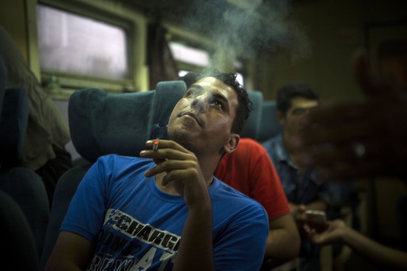 一名在塞爾維亞搭上火車的敘利亞難民,在座位上吞吐著鄉愁。(美聯社) 一名在塞爾維亞搭上火車的敘利亞難民,在座位上吞吐著鄉愁。(美聯社)