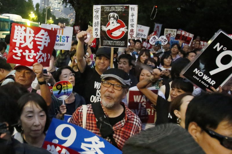 反安保法案的民眾將安倍晉三畫成法西斯。(美聯社) 反安保法案的民眾將安倍晉三畫成法西斯。(美聯社)