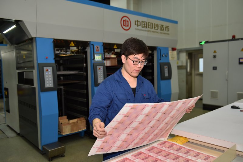 北鈔公司工作人員在抽查新版百元鈔票凹印效果(新華社) 北鈔公司工作人員在抽查新版百元鈔票凹印效果(新華社)