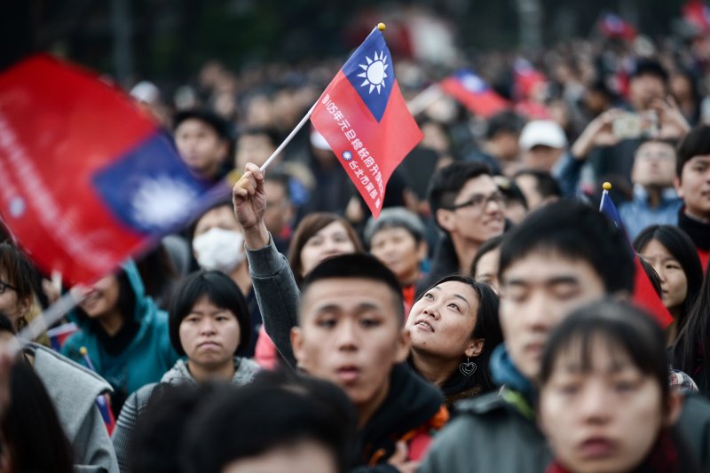 105年元旦升旗典禮在凱道舉行,一位女士看著高舉手上的國旗揮舞。(林俊耀攝) 105年元旦升旗典禮在凱道舉行,一位女士看著高舉手上的國旗揮舞。(林俊耀攝)