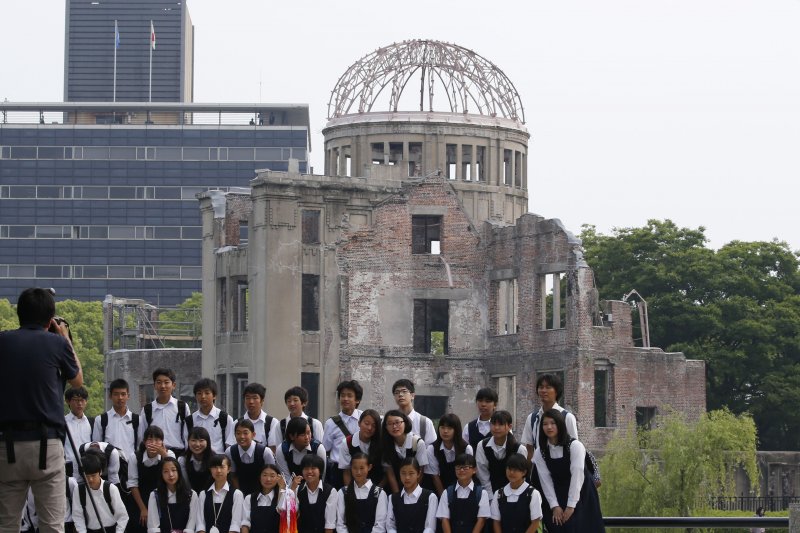 日本學童在廣島原爆留下的的建築物「原子彈爆炸圓頂屋」（Genbaku Dome）前留影。（美聯社）