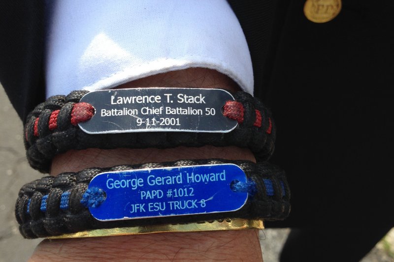 紐約消防局17日為九一一事件罹難消防員史塔克(Lawrence Stack)舉行葬禮,昔日部屬展示他的手環。(美聯社) 紐約消防局17日為九一一事件罹難消防員史塔克(Lawrence Stack)舉行葬禮,昔日部屬展示他的手環。(美聯社)