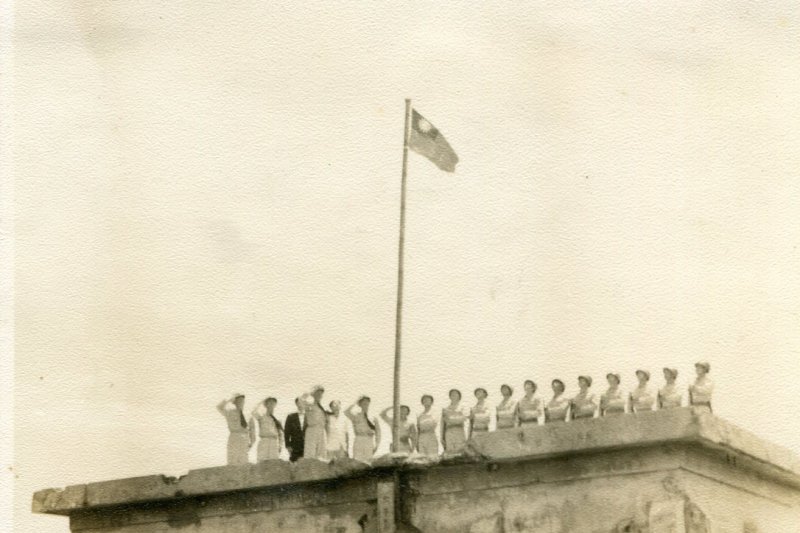 南海風雲。曾任南沙管理處主任彭運生少將，民國45年6月隨海軍立威支隊重返太平島時，與一同偵巡的官兵弟兄們站在標有太平島的建築物屋頂上升旗（內政部）