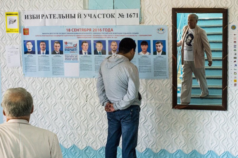 俄國新西伯利亞(Novosibirsk)的選民在投票所觀看選舉公報。(美聯社) 俄國新西伯利亞(Novosibirsk)的選民在投票所觀看選舉公報。(美聯社)