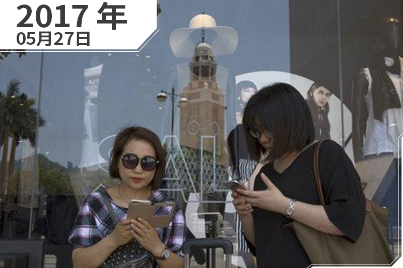 香港,2名女遊客在購物中心外面滑手機(照片:AP/製圖:風傳媒) 香港,2名女遊客在購物中心外面滑手機(照片:AP/製圖:風傳媒)