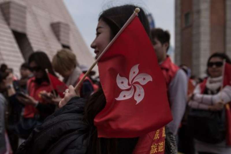 香港民眾手持特區區旗。（BBC中文網）