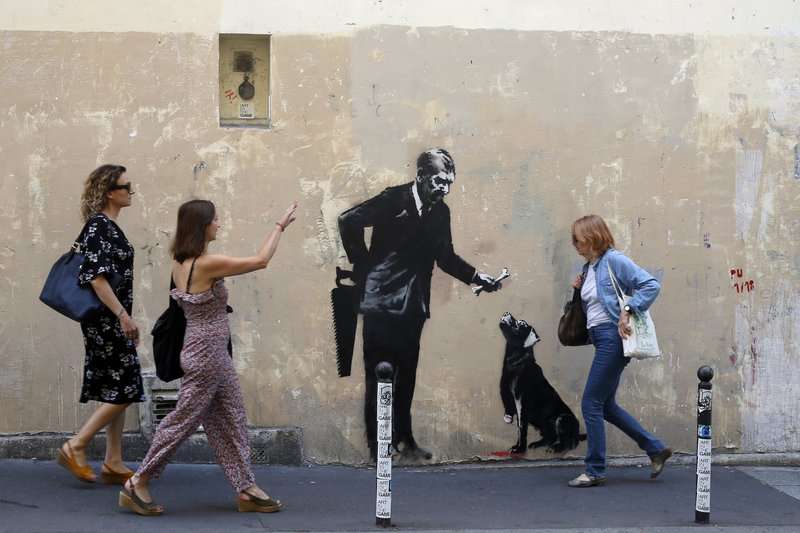 2018年6月25日,民眾經過英國知名街頭藝術家班克西(Banksy)在巴黎的最新塗鴉。(AP) 2018年6月25日,民眾經過英國知名街頭藝術家班克西(Banksy)在巴黎的最新塗鴉。(AP)