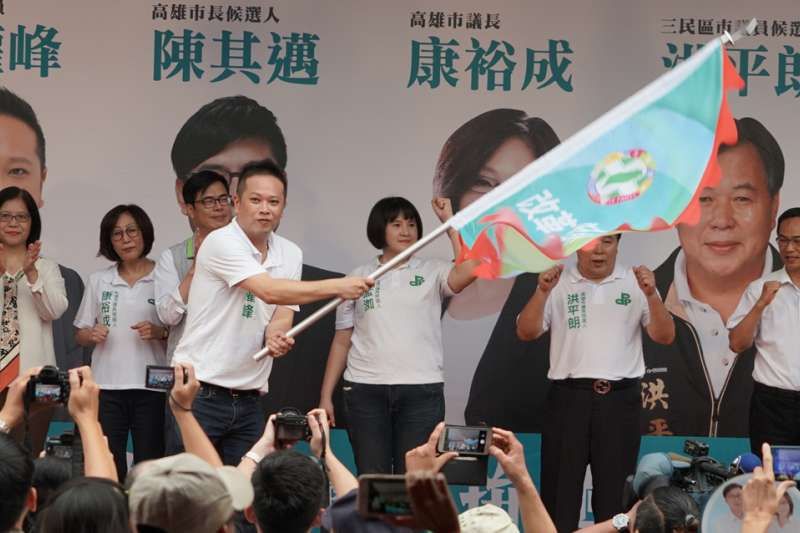 高雄市議員何權峰揮舞著戰旗象徵民進黨團結拚年底選戰。（圖／徐炳文攝）