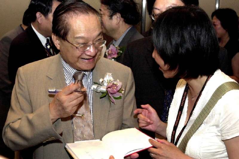 這是2001年7月22日,金庸(左)在2001香港書展上為讀者簽名留念。(新華社) 這是2001年7月22日,金庸(左)在2001香港書展上為讀者簽名留念。(新華社)