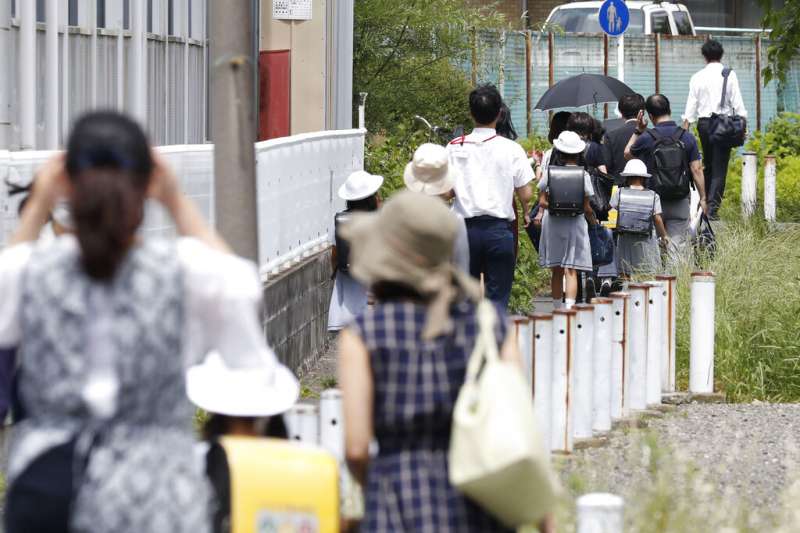 川崎市28日傳出無差別殺人案，當地家長紛紛接送自家孩子上下學。（美聯社）