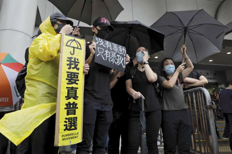 香港民眾手持「我要真普選」標語,冒雨聲援7月28日上環衝突中被控「暴動罪」的44人。(AP) 香港民眾手持「我要真普選」標語,冒雨聲援7月28日上環衝突中被控「暴動罪」的44人。(AP)