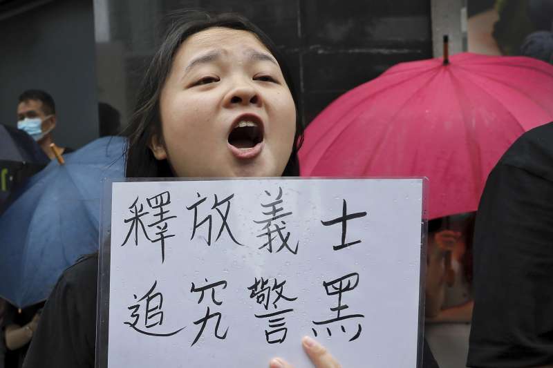 香港民眾手持「釋放義士、追究警黑」標語,聲援7月28日上環衝突中被控「暴動罪」的44人。(AP) 香港民眾手持「釋放義士、追究警黑」標語,聲援7月28日上環衝突中被控「暴動罪」的44人。(AP)