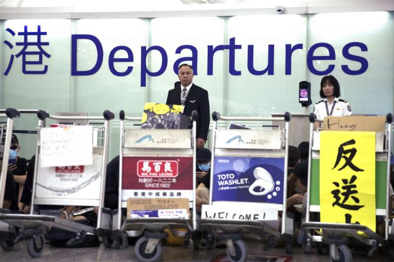 抗議「反送中」與「爆眼少女」的群眾連續第二天現身香港國際機場,癱瘓離境大廳與機場運作。(美聯社) 抗議「反送中」與「爆眼少女」的群眾連續第二天現身香港國際機場,癱瘓離境大廳與機場運作。(美聯社)
