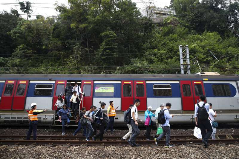 由於列車電纜遭到干擾、鐵軌附近也被投擲雜物，香港列車被迫停駛，乘客只能徒步走到車站。（美聯社）