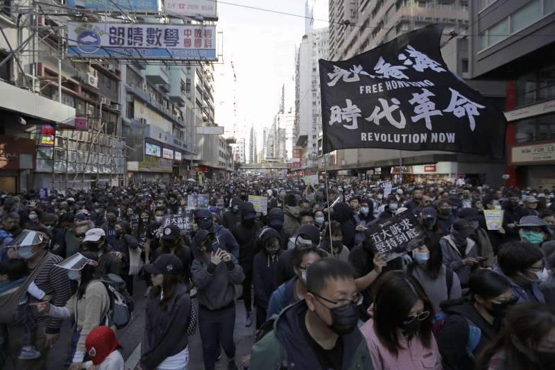 2019年12月8日，香港民陣發起「12.8國際人權日」遊行，參與者舉出「光復香港．時代革命」標語（AP）