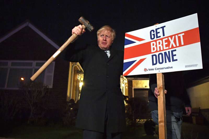 英國12日提前大選,首相強森把握最後機會亮相造勢,牌子寫著主打競選口號「搞定脫歐」。(AP) 英國12日提前大選,首相強森把握最後機會亮相造勢,牌子寫著主打競選口號「搞定脫歐」。(AP)
