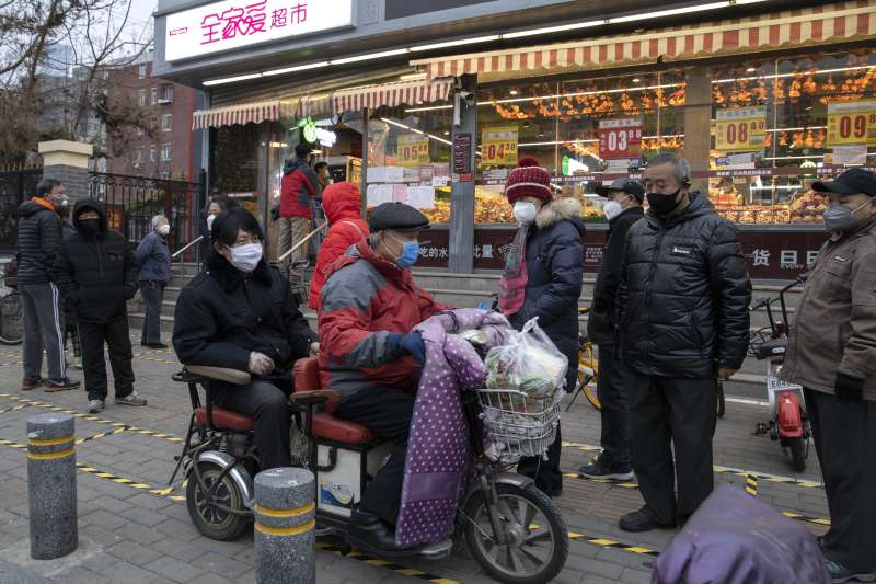 中國武漢肺炎疫情持續延燒，北京市民上街採買時皆戴上口罩。（AP）