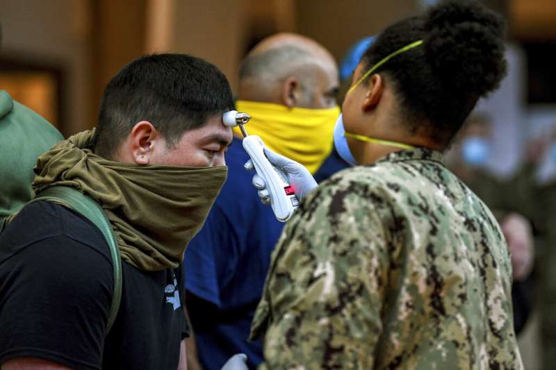 美軍的醫療人員正在為「羅斯福號」水兵進行病毒篩檢。值得注意的是,水兵們並沒有配戴口罩,而是用衣物克難代替。(美聯社) 美軍的醫療人員正在為「羅斯福號」水兵進行病毒篩檢。值得注意的是,水兵們並沒有配戴口罩,而是用衣物克難代替。(美聯社)