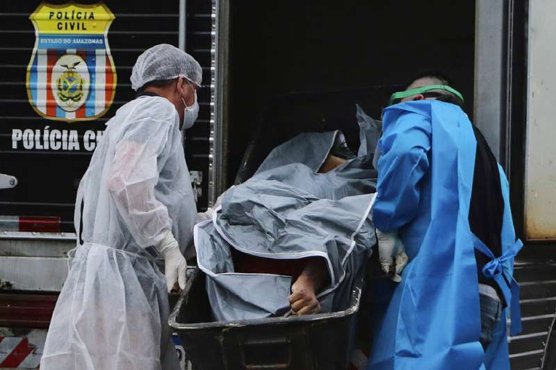 巴西的醫護人員正在將確診死亡的患者遺體送上車。(美聯社) 巴西的醫護人員正在將確診死亡的患者遺體送上車。(美聯社)