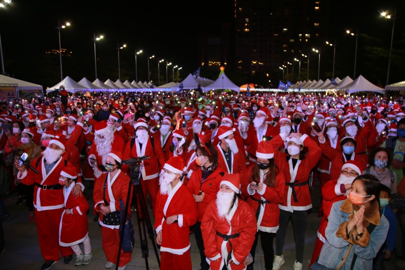 24日晚間的2021台中好聖誕活動，台中市政府前廣唱集結了1001位聖誕老公公歡唱活動主題曲「聖誕哇嘎哩」，並至百貨商場、社區鄰里報佳音。(圖/台中市政府)
