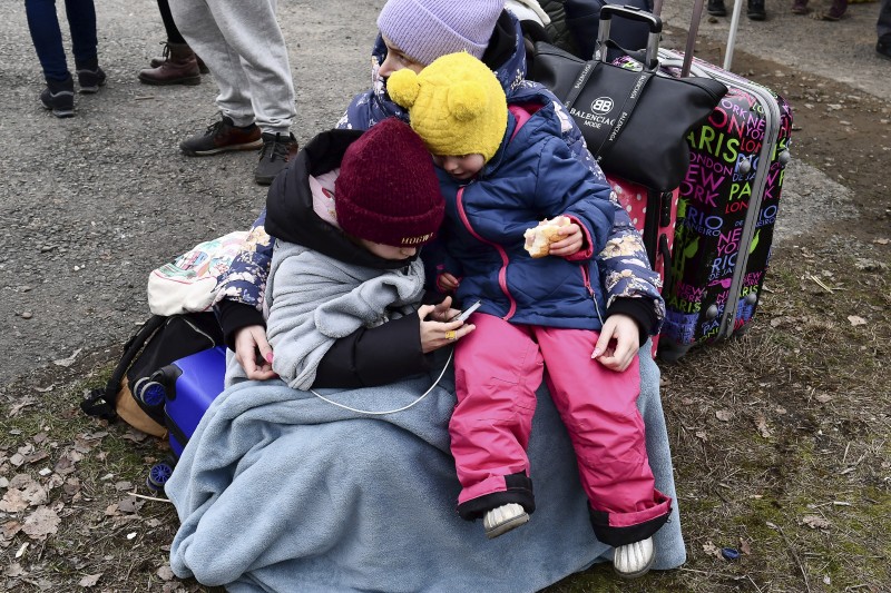 2022年2月26日，一名烏克蘭婦女抱著兩個孩子，在匈牙利邊境的貝雷格蘇拉尼村檢查哨等待（美聯社）