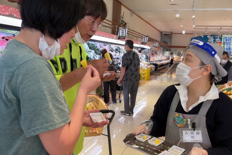 高雄金鑽鳳梨與玉荷包荔枝在日本千葉超市舉辦試吃推廣活動,現場消費者反應熱絡。(圖/農業局提供)