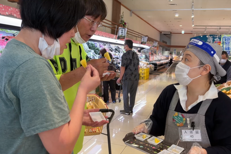 高雄金鑽鳳梨與玉荷包荔枝在日本千葉超市舉辦試吃推廣活動，現場消費者反應熱絡。（圖/農業局提供）