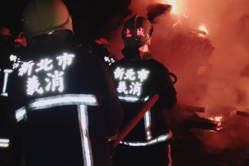 新北市義勇消防人員背負水線深入火場周邊進行滅火操作，展現平時訓練累積的救災能力與實戰默契。（圖／新北市政府消防局提供）