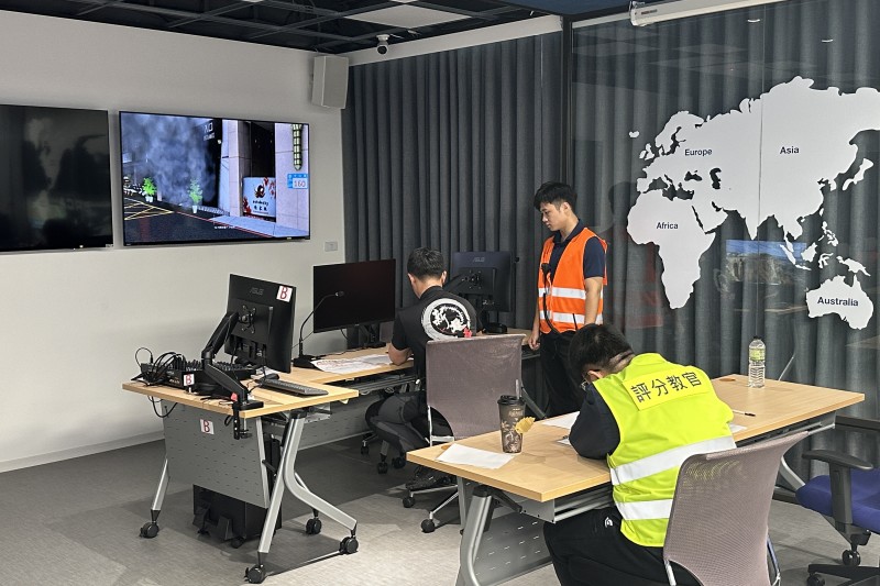 ERCA 透過模擬螢幕呈現火場畫面，受訓人員在遠端進行戰術判斷，評分教官同步觀察並記錄表現，強化指揮決策訓練流程，且利於事後回顧檢討（AAR）。（圖／新北市政府消防局提供）