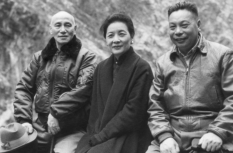 1955前後，宋美齡與蔣介石、蔣經國父子坐在石牆上。（Getty/Hulton Archive）