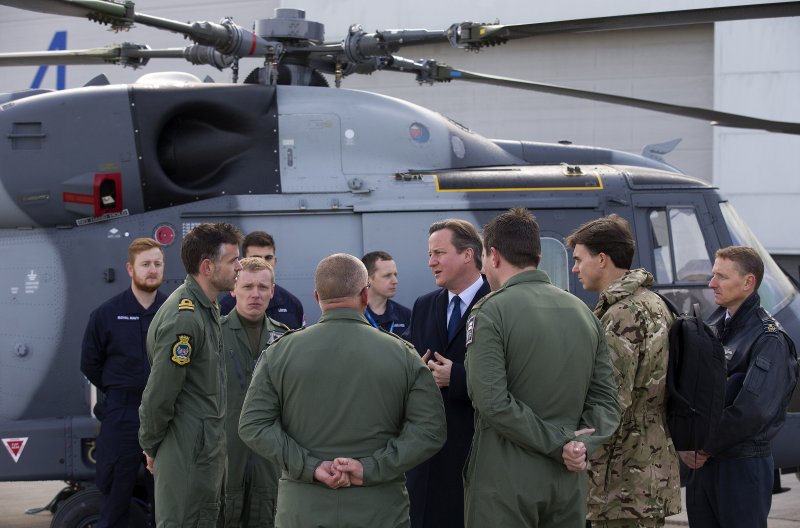 英國首相卡麥隆(中著西裝者)23日視察英國皇家空軍。(美聯社) 英國首相卡麥隆(中著西裝者)23日視察英國皇家空軍。(美聯社)