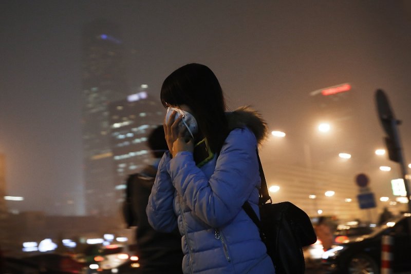 中國女子掩蓋口鼻減輕汙染影響(美聯社) 中國女子掩蓋口鼻減輕汙染影響(美聯社)