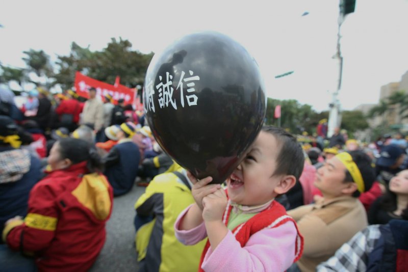 2017-01-22-總統府年金改革國是會議-軍公教團體場外抗議16-小孩玩著政府誠信汽球-陳明仁攝