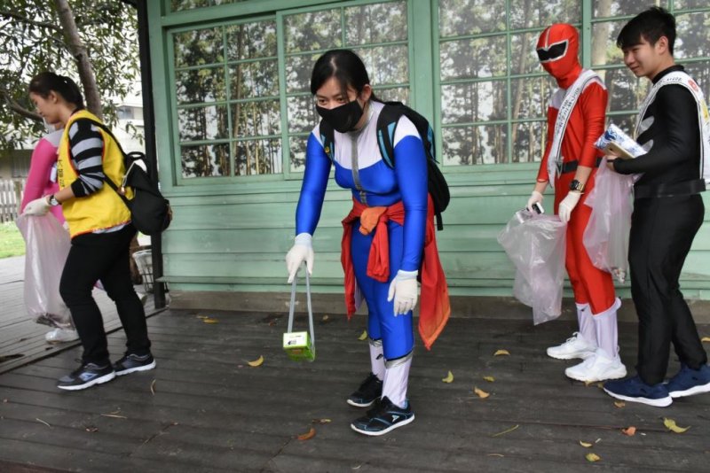 2017台日變裝竹東掃街，男女變裝超人認真撿拾街上垃圾。（圖／新竹縣政府提供）