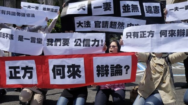 反對同婚人士3月24日憲法法庭開庭日在司法院外舉標語抗議。（BBC中文網）