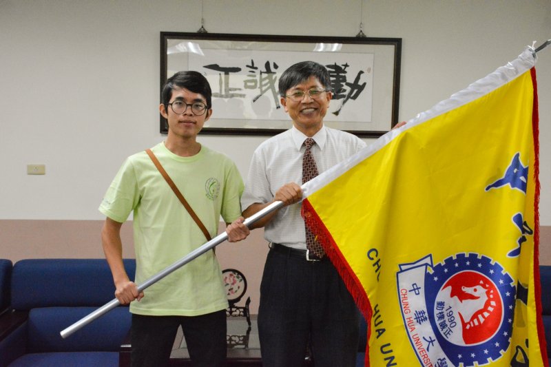 中華大學學務長廖述濤授旗予國際志工團團長關榮，期勉讓世界更多人看見台灣。(圖／中華大學提供)