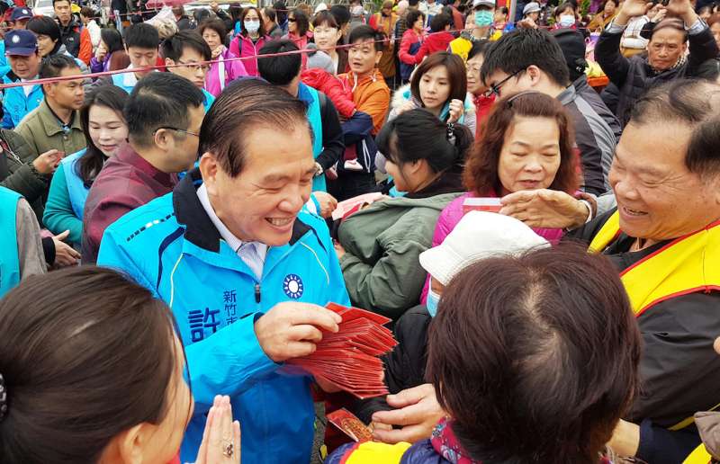 前新竹市長許明財在天公壇前發紅包，吸引民眾們爭相索取，受歡迎程度不減當年。（圖／方詠騰攝）