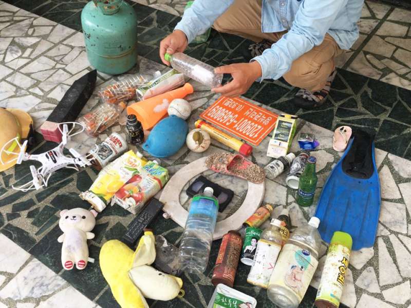 陳大哥展示他的戰利品:他手上拿著印尼來的瓶中信,第上攤開的則有布偶、馬桶蓋、來自各國的飲品包裝、保險套、蛙鞋、空拍機等。什麼都有,什麼都不奇怪。(圖/鐘敏瑜攝) 陳大哥展示他的戰利品:他手上拿著印尼來的瓶中信,第上攤開的則有布偶、馬桶蓋、來自各國的飲品包裝、保險套、蛙鞋、空拍機等。什麼都有,什麼都不奇怪。(圖/鐘敏瑜攝)
