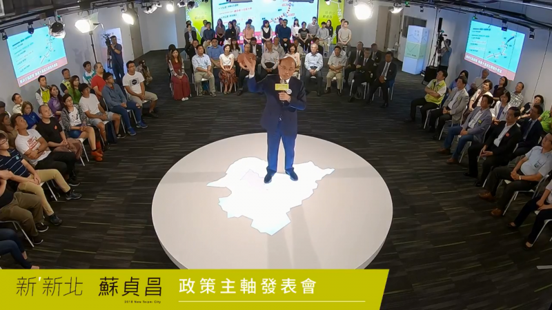 20180724-新北市長參選人蘇貞昌24日發布政策主軸,同時公布象徵新新北「環形城市」的動態3D主視覺。本次政見發布的舞台,團隊同樣以「環狀舞台」為概念,扣連「環形城市」理念。(截圖自YouTube影片) 20180724-新北市長參選人蘇貞昌24日發布政策主軸,同時公布象徵新新北「環形城市」的動態3D主視覺。本次政見發布的舞台,團隊同樣以「環狀舞台」為概念,扣連「環形城市」理念。(截圖自YouTube影片)