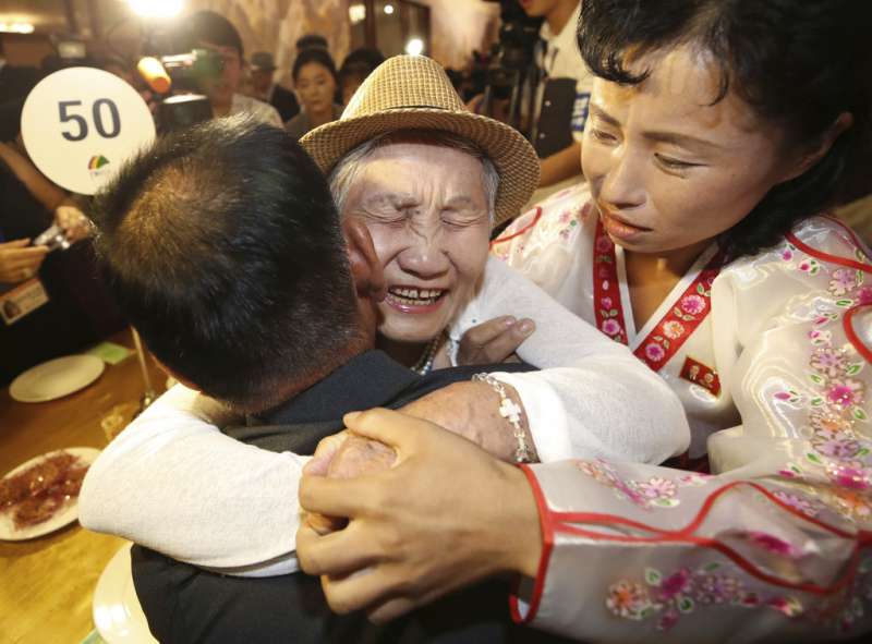 2018年8月20日，92歲母親李金纖（中）與71歲兒子李相哲激動相擁。（AP）