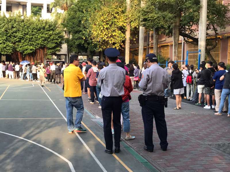 2018年九合一選舉投票四點結束但排隊者仍非常多,警察站隊伍最後。(呂紹煒攝) 2018年九合一選舉投票四點結束但排隊者仍非常多,警察站隊伍最後。(呂紹煒攝)