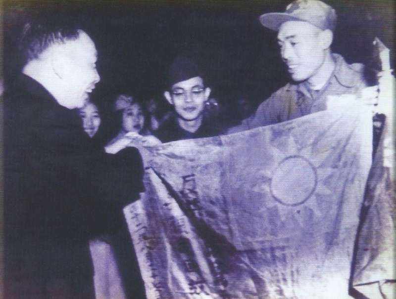 1954年(民國43年)1月,義士代表將他們在濟州島戰俘營以鮮血染成的中華民國國旗,獻給時任國防會議副秘書長蔣經國先生,圖片來源:《抉擇──一萬四千名反共義士(輔導會/103.01.23出版/勒巴克顧問公司承印)》,作者賈忠偉提供 1954年(民國43年)1月,義士代表將他們在濟州島戰俘營以鮮血染成的中華民國國旗,獻給時任國防會議副秘書長蔣經國先生,圖片來源:《抉擇──一萬四千名反共義士(輔導會/103.01.23出版/勒巴克顧問公司承印)》,作者賈忠偉提供