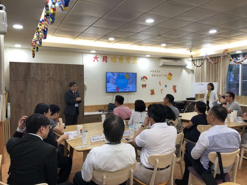 大同醫院院長陳彥旭(左站立者)為長樂集團介紹福樂學堂經營模式。（圖／徐炳文攝）