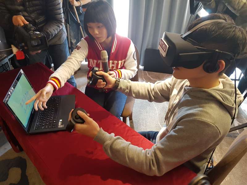 清大學生使用頭戴式VR眼罩及手持式搖桿就可以放大、縮小及旋轉檢視人體器官細節。(圖/方詠騰攝) 清大學生使用頭戴式VR眼罩及手持式搖桿就可以放大、縮小及旋轉檢視人體器官細節。(圖/方詠騰攝)