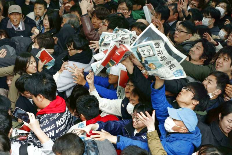 安倍政府1日終於公布新年號「令和」,日本媒體也忙著在街頭發送快報。(美聯社) 安倍政府1日終於公布新年號「令和」,日本媒體也忙著在街頭發送快報。(美聯社)