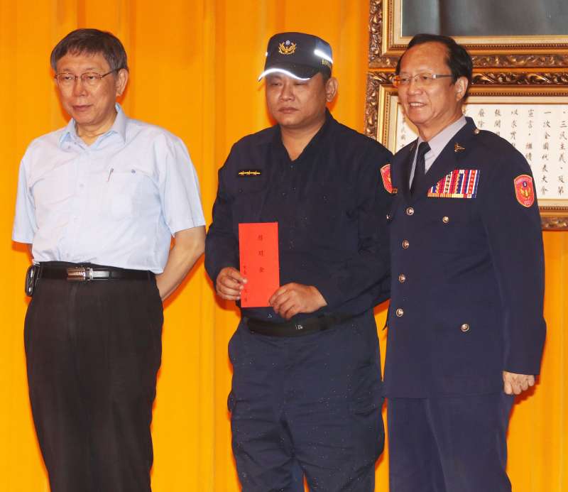 20190705-萬華分局警員張景義2013年為制止暴衝車輛在西門町高速衝撞傷及無辜,開槍打中駕車的黎姓男子,黎男送醫不治,到今年5月才無罪定讞。圖為日前在台北市警察局金吾獎頒獎典禮上,張景義(中)接受市長柯文哲、警察局長陳嘉昌表揚。(蘇仲泓攝) 20190705-萬華分局警員張景義2013年為制止暴衝車輛在西門町高速衝撞傷及無辜,開槍打中駕車的黎姓男子,黎男送醫不治,到今年5月才無罪定讞。圖為日前在台北市警察局金吾獎頒獎典禮上,張景義(中)接受市長柯文哲、警察局長陳嘉昌表揚。(蘇仲泓攝)