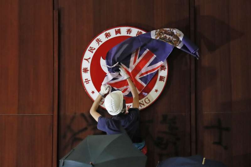 反送中示威群眾用港英旗遮蓋香港立法會內的區徽(AP) 反送中示威群眾用港英旗遮蓋香港立法會內的區徽(AP)