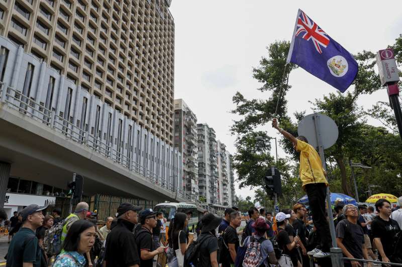 部分反送中民眾在遊行中揮舞港英旗。(美聯社) 部分反送中民眾在遊行中揮舞港英旗。(美聯社)