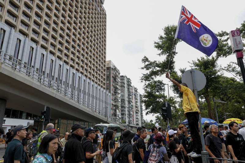 部分反送中民眾在遊行中揮舞港英旗。（美聯社）